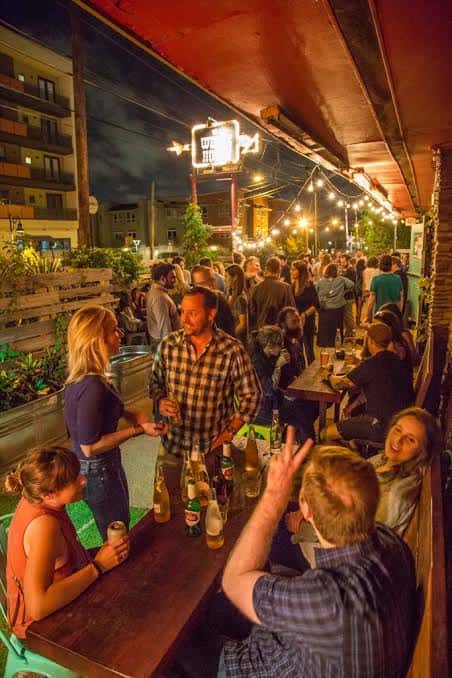 Terraza exterior del The White Horse llena de gente socializando bajo luces de fiesta