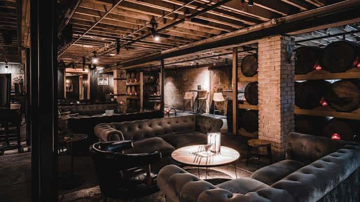 Zona lounge con sofás tapizados y barriles decorativos