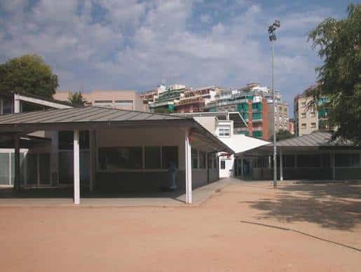 Vista exterior del centro cívico con zonas de sombra y entorno urbano al fondo