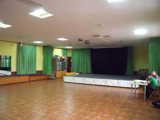 Sala de eventos con escenario y cortinas verdes
