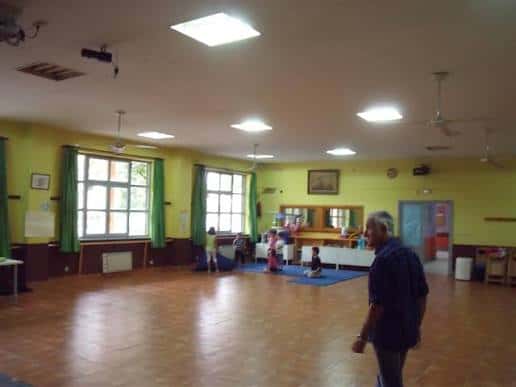 Interior de la sala con personas y mobiliario