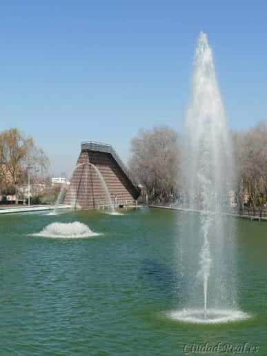 Fuentes en primer plano con el monumento piramidal al fondo bajo cielo despejado