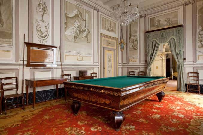 Sala de juegos con mesa de billar y decoración clásica