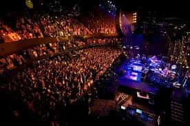 Concierto en vivo con el público lleno y el escenario iluminado