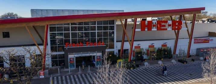 Vista exterior del H-E-B en 7th Street con su distintiva fachada de madera y estructura roja