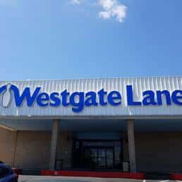 Fachada exterior de Westgate Lanes con letrero azul bajo cielo despejado