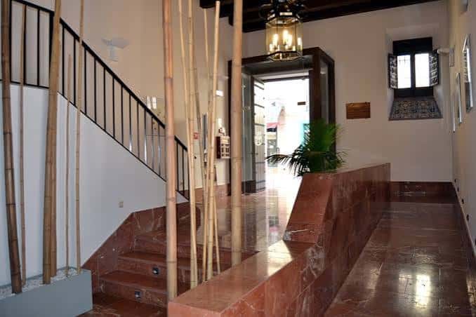 Hall de entrada con escalera de mármol y decoración de bambú