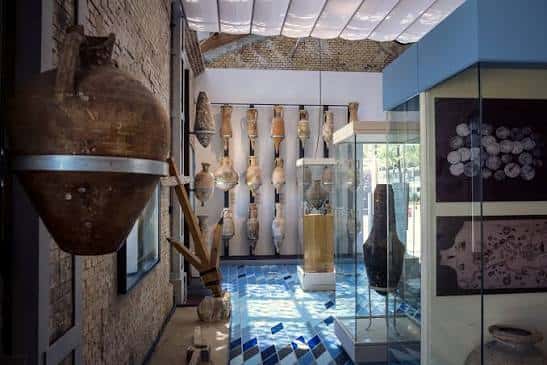 Interior del museo con exposición de ánforas romanas y vitrinas de cerámicas