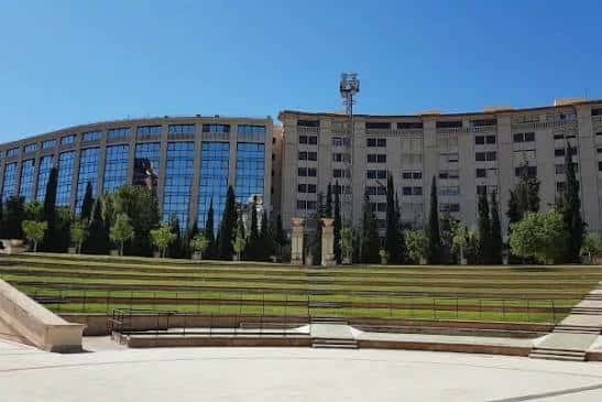 Fachada del auditorio con gradas de césped y cielo despejado