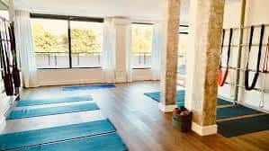 Sala de yoga con esterillas azules y columnas de piedra