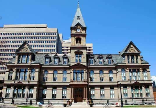 Vista frontal completa de Halifax City Hall con su característica torre y reloj bajo un cielo azul despejado