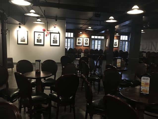 Interior del restaurante con mesas redondas y decoración estilo industrial