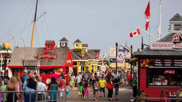 Vista del paseo marítimo con puestos de comida y banderas canadienses