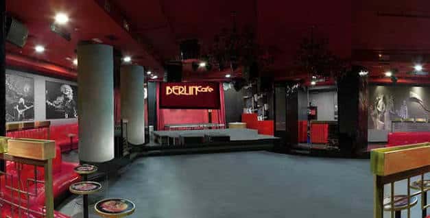 Salón principal con barra, escenario y decoración en tonos rojos