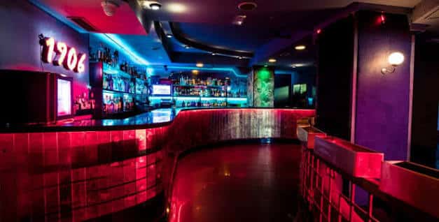 Barra principal con iluminación neón y estantería de bebidas