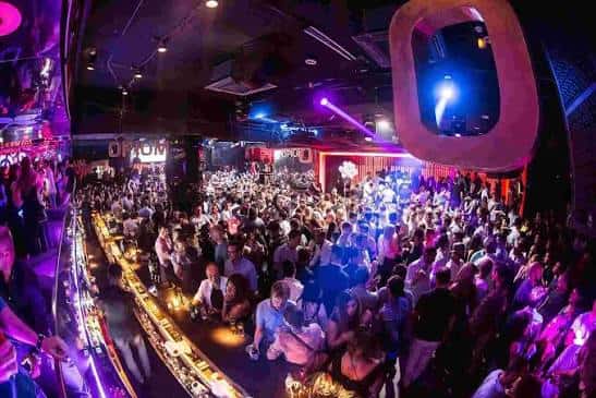 Interior del club Opium con multitud de personas y luces de neón