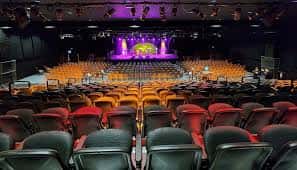 Interior del auditorio del Light House Arts Centre con butacas y escenario iluminado