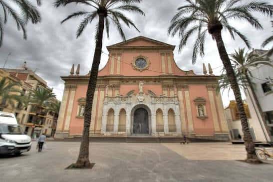 Vista frontal de la Plaça de les Neus con la iglesia de Santa Maria y palmeras