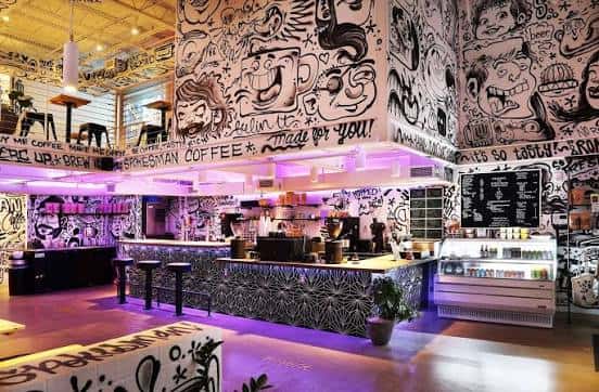 Interior del Spokesman Coffee con decoración de graffiti y barra de servicio