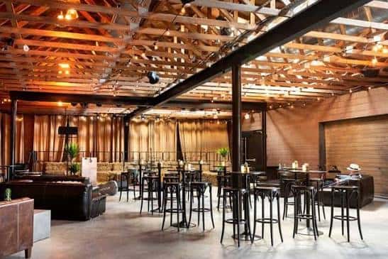 Interior del salón principal con techo de vigas de madera y mobiliario para eventos