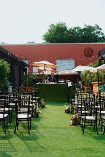 Ceremonia al aire libre en el patio con césped artificial y decoración floral