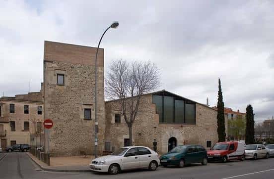 Vista exterior del Centre Cívic Santa Eugènia mostrando la fachada de piedra y la ampliación moderna con grandes ventanales