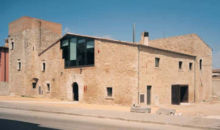 Fachada principal del edificio en un día soleado, destacando la arquitectura tradicional y contemporánea