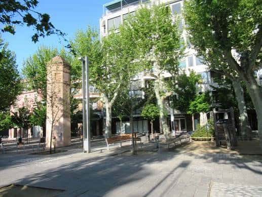 Plaza de la Corona con árboles y edificios modernos al fondo