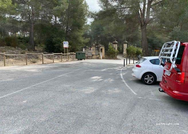 Vista general del parking del Pont del Diable con vehículos estacionados y entorno arbolado