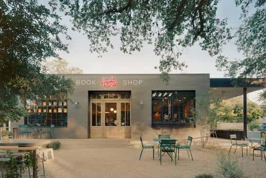 Vista exterior de la librería First Light Books con patio y mesas al atardecer