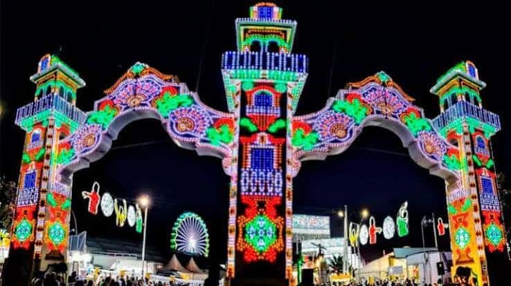 Arco de entrada principal del recinto ferial con iluminación festiva y colorida