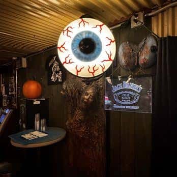 Decoración temática con ojo gigante y elementos de Halloween en el bar
