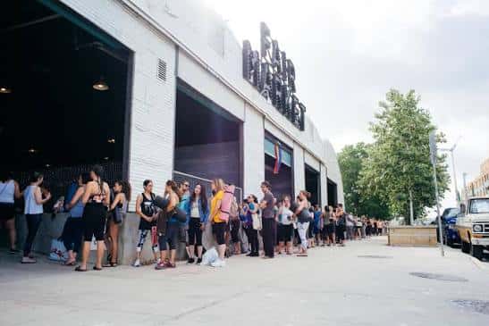Exterior del local con una fila de personas esperando la entrada