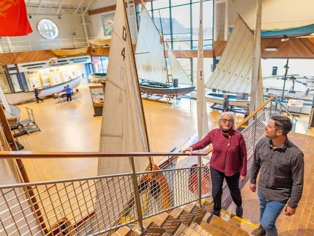 Interior del museo con modelos de veleros y visitantes en escalera