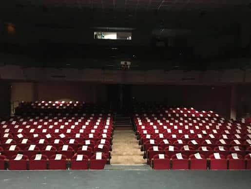 Interior del auditorio con butacas rojas y escenario