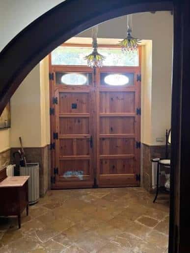 Entrada principal con puertas de madera y arco decorativo