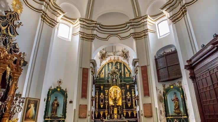 Interior del convento con altar barroco dorado y bóvedas decoradas