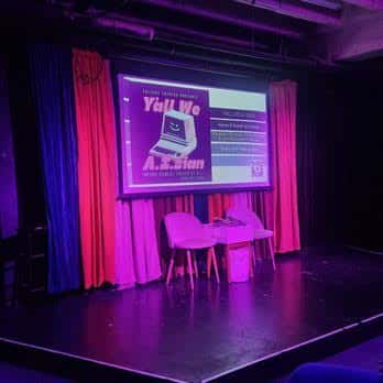 Escenario del teatro con cortinas y pantalla de proyección