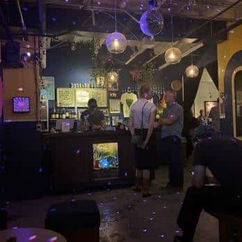 Área del bar con clientes y decoración con luces