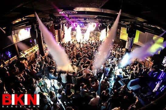 Vista panorámica del interior de la discoteca con público y luces de escenario
