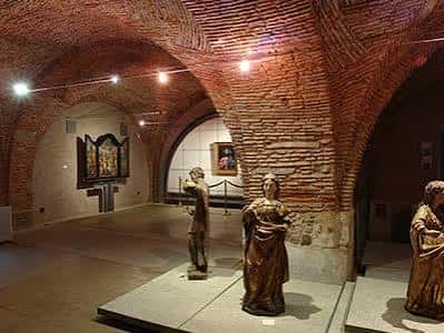 Sala interior del museo con bóvedas de ladrillo y esculturas expuestas