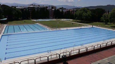 Vista panorámica de las piscinas municipales con montañas al fondo