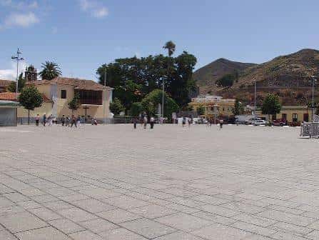 Vista amplia de la plaza con edificios coloniales y montañas al fondo
