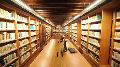 Sala de lectura con estanterías y mesas de trabajo