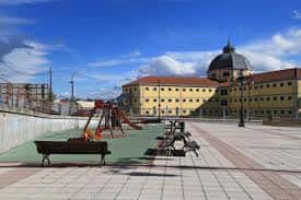 Vista panorámica de la Plaza de Juan Pablo II con el edificio emblemático y zona de juegos infantiles