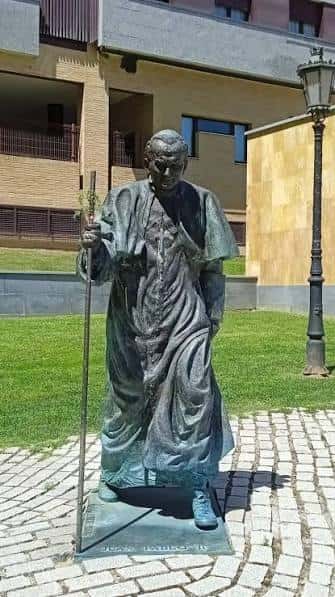 Estatua de bronce del Papa Juan Pablo II en la plaza, con detalle de su vestimenta y bastón