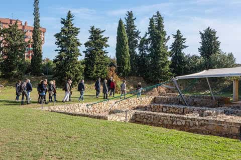 Grupo de visitantes recorriendo el yacimiento arqueológico al aire libre