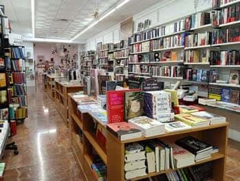 Interior de la librería con estanterías llenas de libros y mesas de exhibición