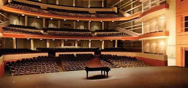 Interior del auditorio principal con un piano de cola en el escenario y butacas dispuestas en niveles