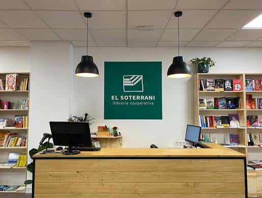Mostrador de atención al cliente con el logo de la librería en la pared